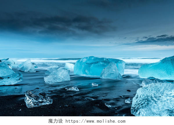 蓝色南冰岛黑色沙滩上的水晶冰山